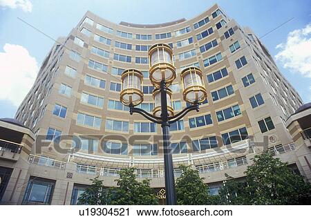 Stock Image - Streetlights in front of tall building. Fotosearch