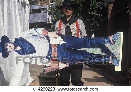 Stock Image - Cowboy in full costume with cardboard cutout. Fotosearch