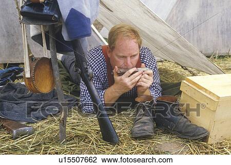 Stock Image - Confederate participant in camp scene playing mouth harp during recreation of Battle of Manassas. Fotosearch