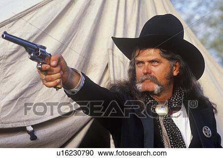Stock Image - Living History participant posing as US Marshall pointing gun. Fotosearch