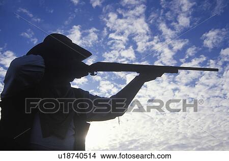 Picture - Silhouette of Cowboy aiming rifle. Fotosearch