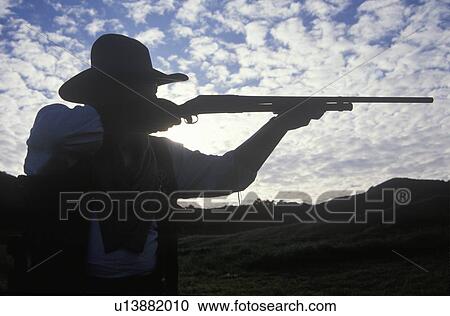 Silhouette of Cowboy aiming rifle View Large Photo Image Stock Image - Silhouette of Cowboy aiming rifle. Fotosearch