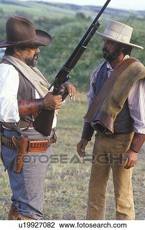 Stock Image - Two cowboys in full costume during historical reenactment. Fotosearch