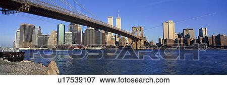 Stock Photo - Panoramic view of East River and Brooklyn Bridge going to lower Manhattan, New York City, New York with World Trade Center. Fotosearch
