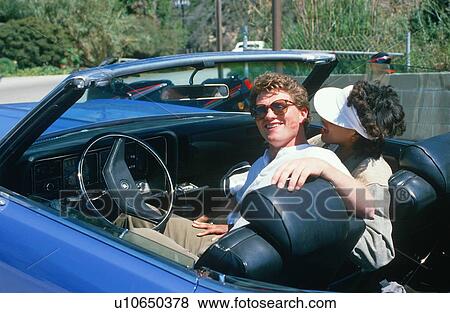 Stock Photo - A couple in a blue convertible. Fotosearch