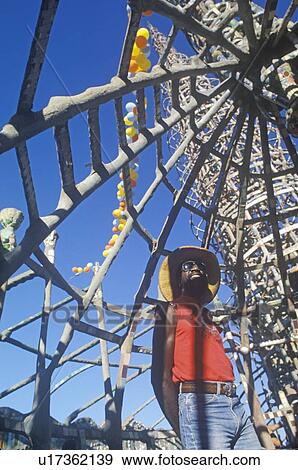 Stock Photo - African American male poses with the Watts Towers, 20th Anniversary of the 1965 riots. Fotosearch