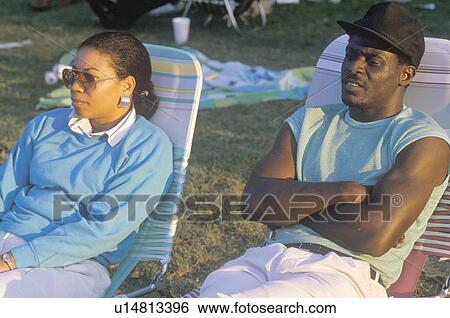 Stock Photograph - An African-American couple on lawn chairs. Fotosearch