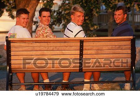 Stock Photo - Four college aged men on a park bench. Fotosearch