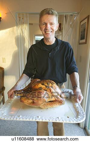 Man carrying in Thanksgiving turkey for dinner View Large Photo Image Stock Photo - Man carrying in Thanksgiving turkey for dinner. Fotosearch
