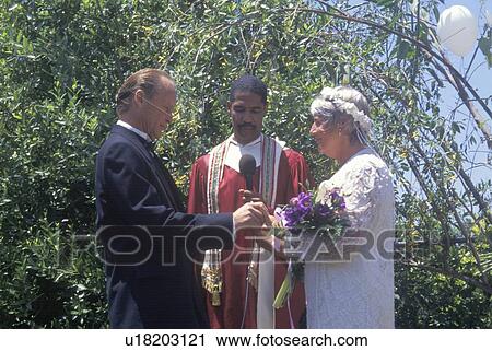 Stock Image - Middle aged bride and groom at an outdoor wedding ceremony. Fotosearch