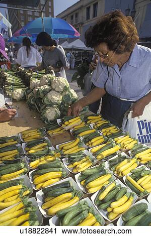 Stock Image - Woman selecting squash. Fotosearch