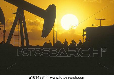 Oil drilling well silhouetted at sunset View Large Photo Image Picture - Oil drilling well silhouetted at sunset. Fotosearch