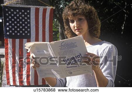 Woman voter reading election pamphlet at the entrance to a polling place View Large Photo Image Stock Photo - Woman voter reading election pamphlet at the entrance to a polling place. Fotosearch