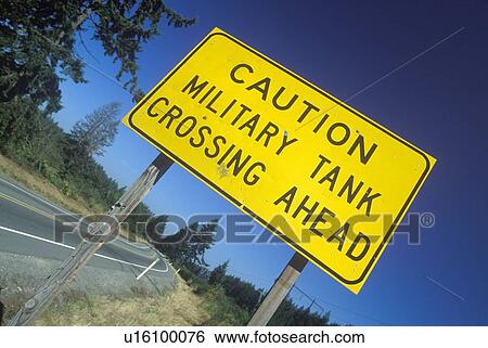 Stock Photograph - A sign that reads “Caution - Military tank crossing ahead”. Fotosearch