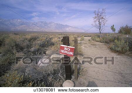 Stock Image - No trespassing sign at dirt road toward the Sierra Mountains, California. Fotosearch