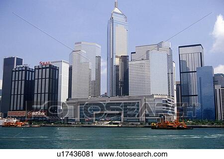 Stock Image - City skyline and ferry in Hong Kong Harbor. Fotosearch