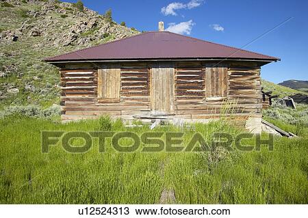 Stock Image - Deserted old prairie log cabin in Centennial Valley near Lakeview. Fotosearch