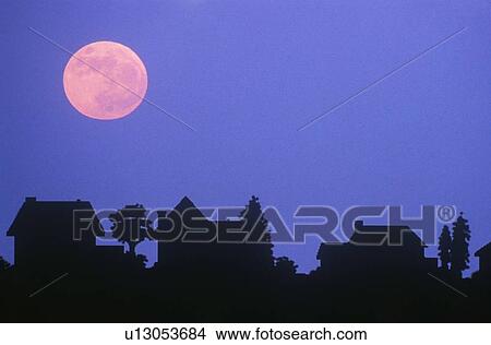 Picture - Silhouette of full moon over family homes in typical neighborhood. Fotosearch