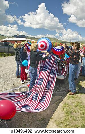 Stock Image - Women decorating a car in red, white & blue. Fotosearch