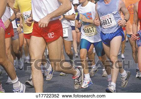 Stock Image - Close-up of runners' legs in marathon. Fotosearch