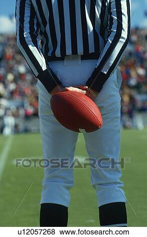Referee holding a football behind his back View Large Photo Image Stock Photo - Referee holding a football behind his back. Fotosearch