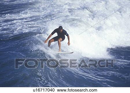 Stock Image - Surfer on crest of wave. Fotosearch