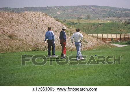Three golfers walking on green View Large Photo Image Stock Photography - Three golfers walking on green. Fotosearch