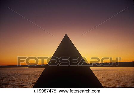 Stock Photography - Silhouette of a pyramid by a lake. Fotosearch