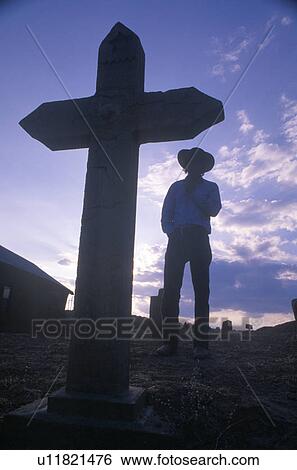 Silhouette of Cowboy next to grave marker at sunset View Large Photo Image Stock Photograph - Silhouette of Cowboy next to grave marker at sunset. Fotosearch