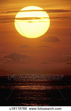 Stock Photograph - Sun Setting Over The Ocean. Fotosearch