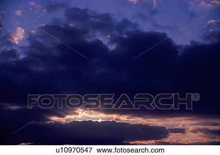 Sun Setting Through Clouds, View Large Photo Image Stock Photo - Sun Setting Through Clouds,. Fotosearch