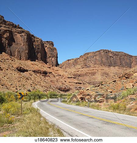 Road curving to right with red rock cliffs in Utah. View Large Photo Image Stock Image - Road curving to right with red rock cliffs in Utah.. Fotosearch
