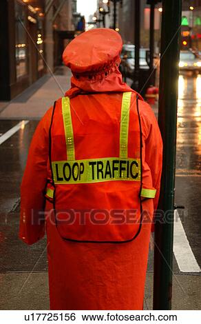 Stock Photograph - Rear view of a traffic personnel standing on the sidewalk. Fotosearch