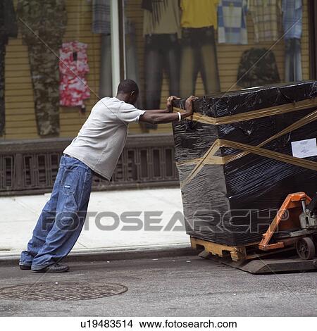 Picture - Man moving a container, New York City. Fotosearch