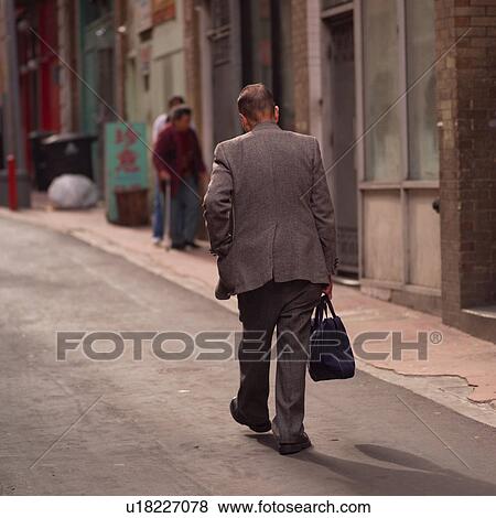 Stock Photo - Man walking down a street in Chinatown San Francisco. Fotosearch