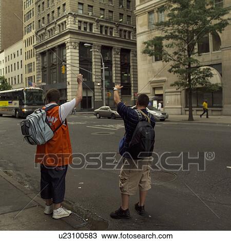 Stock Image - Two men hailing a cab, New York City. Fotosearch