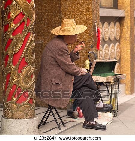 Stock Photo - Vendor smoking a pipe in Chinatown San Francisco. Fotosearch