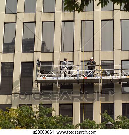 Workers working on a window cleaning platform outside a building View Large Photo Image Stock Image - Workers working on a window cleaning platform outside a building. Fotosearch