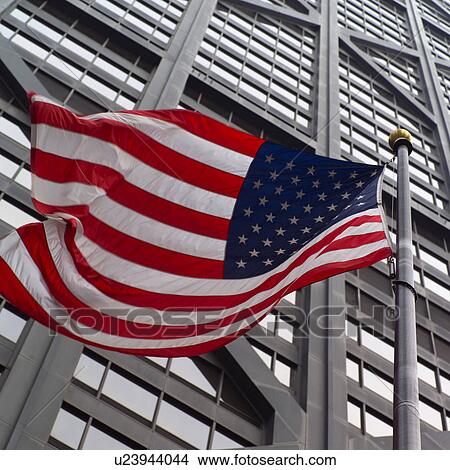 Picture - Low angle view of the American flag outside John Hancock Building in Chicago. Fotosearch