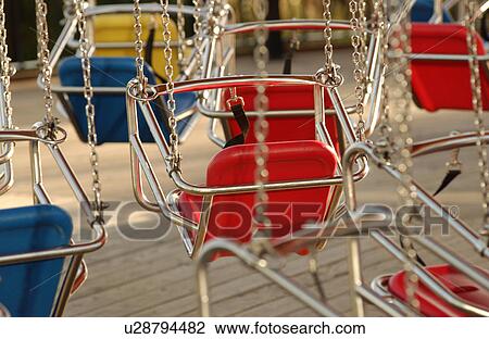 Stock Image - Seats of a merry go round at an amusement park at Navy Pier. Fotosearch