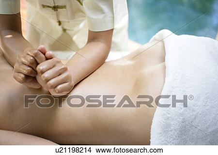 A massager massaging a woman’s back. View Large Photo Image Picture - A massager massaging a woman’s back.. Fotosearch
