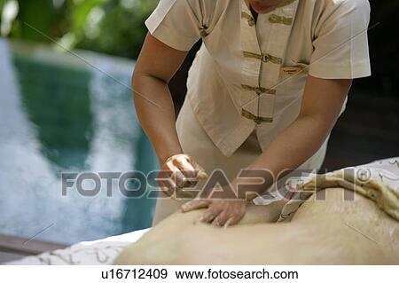 Stock Photo - A massager massaging a woman’s body.. Fotosearch