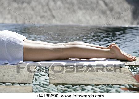 Stock Image - A woman sun bathing.. Fotosearch