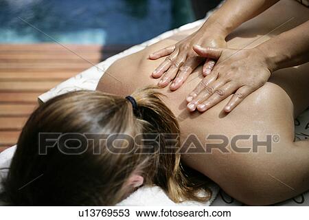Stock Image - A woman taking massage on back.. Fotosearch