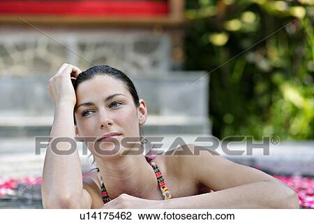 Stock Image - A young woman having aromatherapy bath.. Fotosearch
