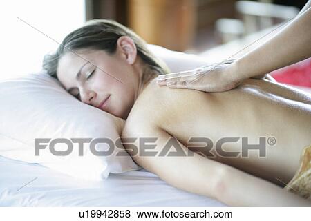 Stock Photo - A young woman lying with eyes closed.. Fotosearch