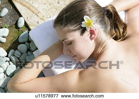 Stock Photo - A young woman sun bathing.. Fotosearch