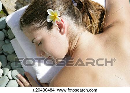 A young woman sun bathing with eyes closed. View Large Photo Image Picture - A young woman sun bathing with eyes closed.. Fotosearch