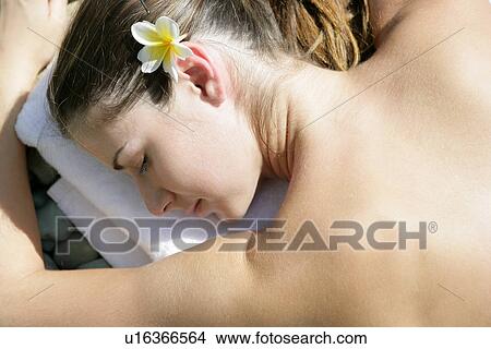 A young woman with a flower in hair. View Large Photo Image Picture - A young woman with a flower in hair.. Fotosearch