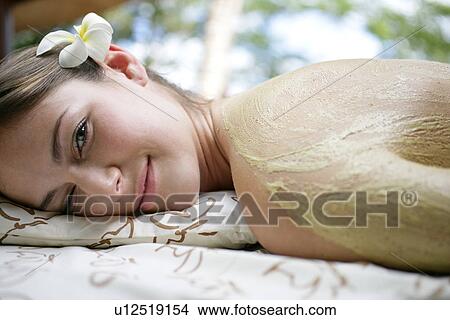 A young woman’s back covered with cream. View Large Photo Image Picture - A young woman’s back covered with cream.. Fotosearch